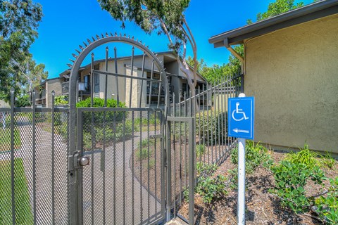 a gate with a blue handicapped sign in front of a house